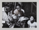 Image of Man Helping Small Girl Drink from Bottle, El Salvador